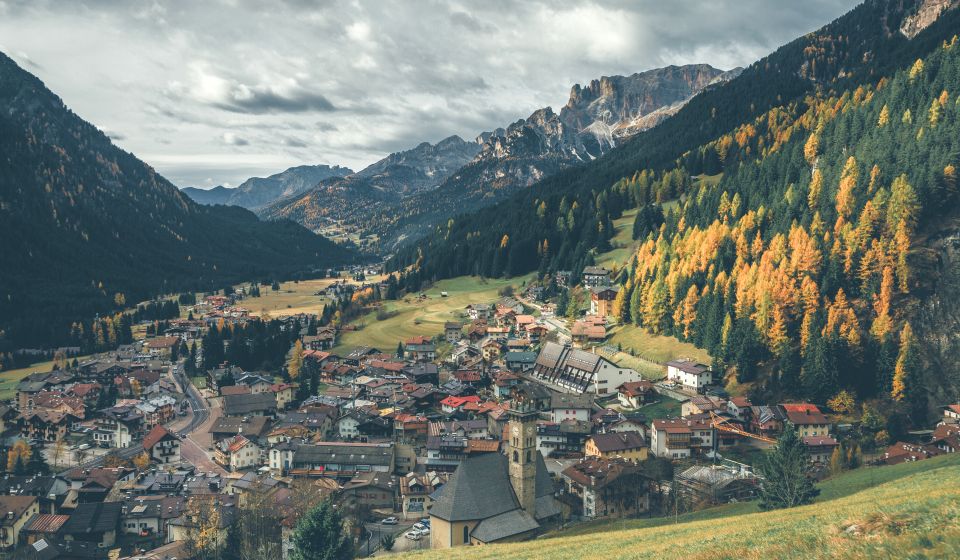 Drohnenblick auf Campitello di Fassa: Ein Bergdorf zwischen Col Rodella, Langkofel und endlosen Dolomitenhimmeln.