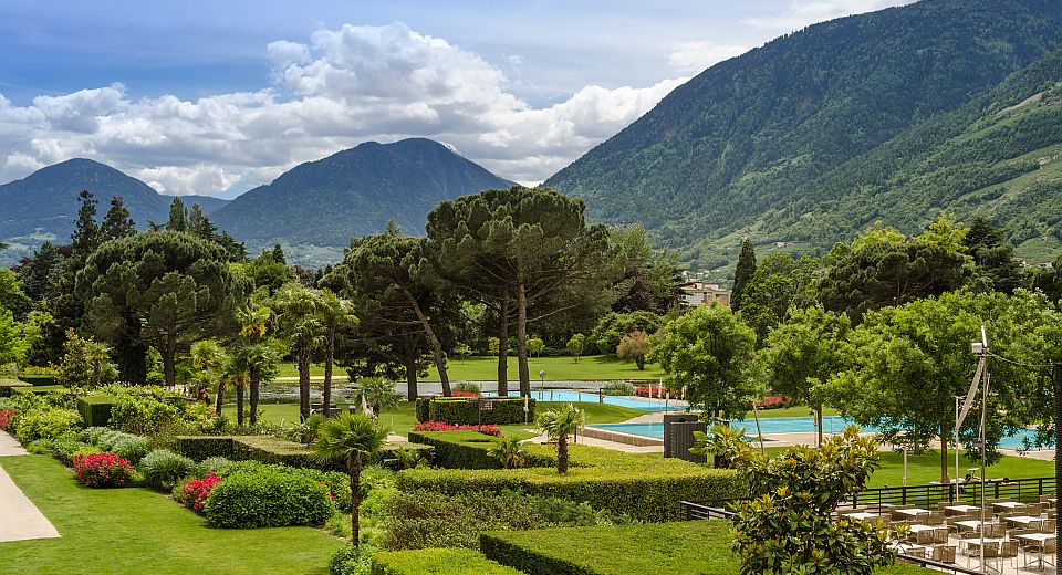 Die grüne Außenanlage der Therme Meran verbindet weitläufige Liegewiesen, alte Bäume und Pools zu einer Oase.