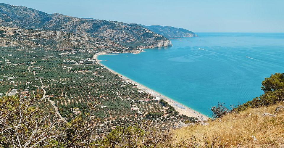 Der Strand von Mattinata begeistert mit hellen Kieseln, kristallklarem Wasser und einer grünen Kulisse des Gargano.