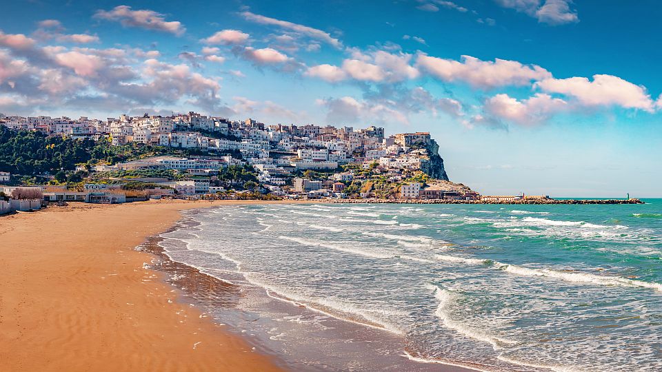 Der Strand von Peschici begeistert mit hellem Sand, klarem Wasser und dem malerischen Ort hoch über der Bucht.