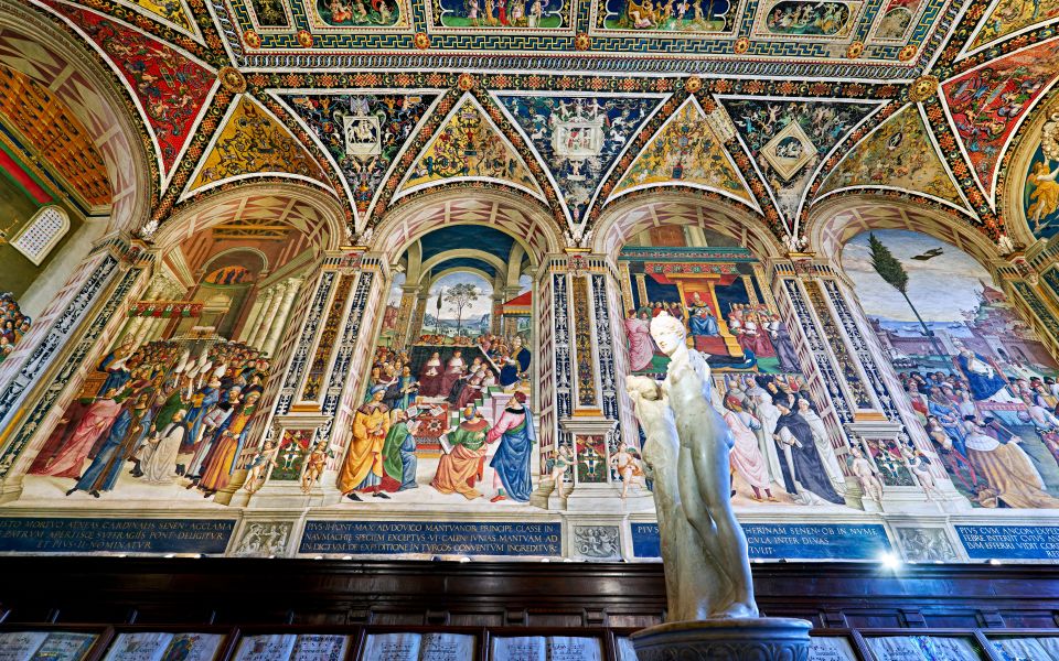 Die Piccolomini-Bibliothek glänzt mit farbenprächtigen Fresken und einem prunkvollen Gewölbe, das wie eine Renaissance-Schatzkammer wirkt.