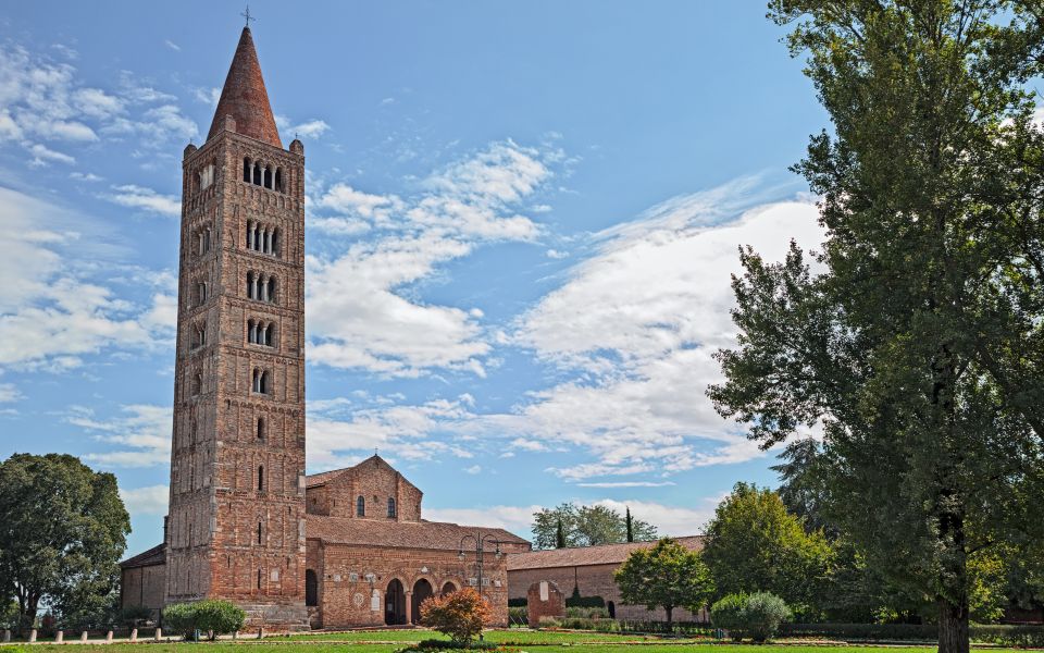 Die Außenansicht der Abtei von Pomposa zeigt romanische Harmonie mit Backstein, Marmor und dem markanten Glockenturm.