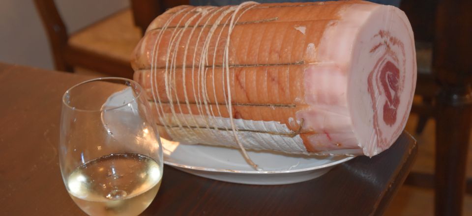 Pancetta in feinen Scheiben, dazu ein Gläschen Wein – eine harmonische Kombination voller italienischem Genuss.