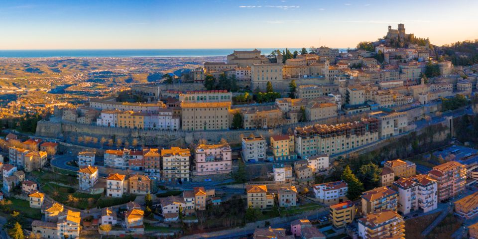 Häuser schmiegen sich an den Monte Titano, während im Hintergrund die Adria glitzert – ein Panorama voller Magie.