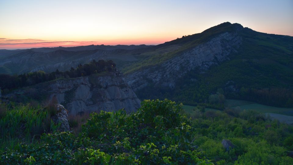 Die Landschaft erwacht im zarten Rosa und Gold des Sonnenaufgangs über der Vena del Gesso Romagnola.