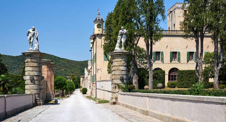 Ein breiter Kiesweg führt durch die Landschaft hin zum Castello del Catajo.