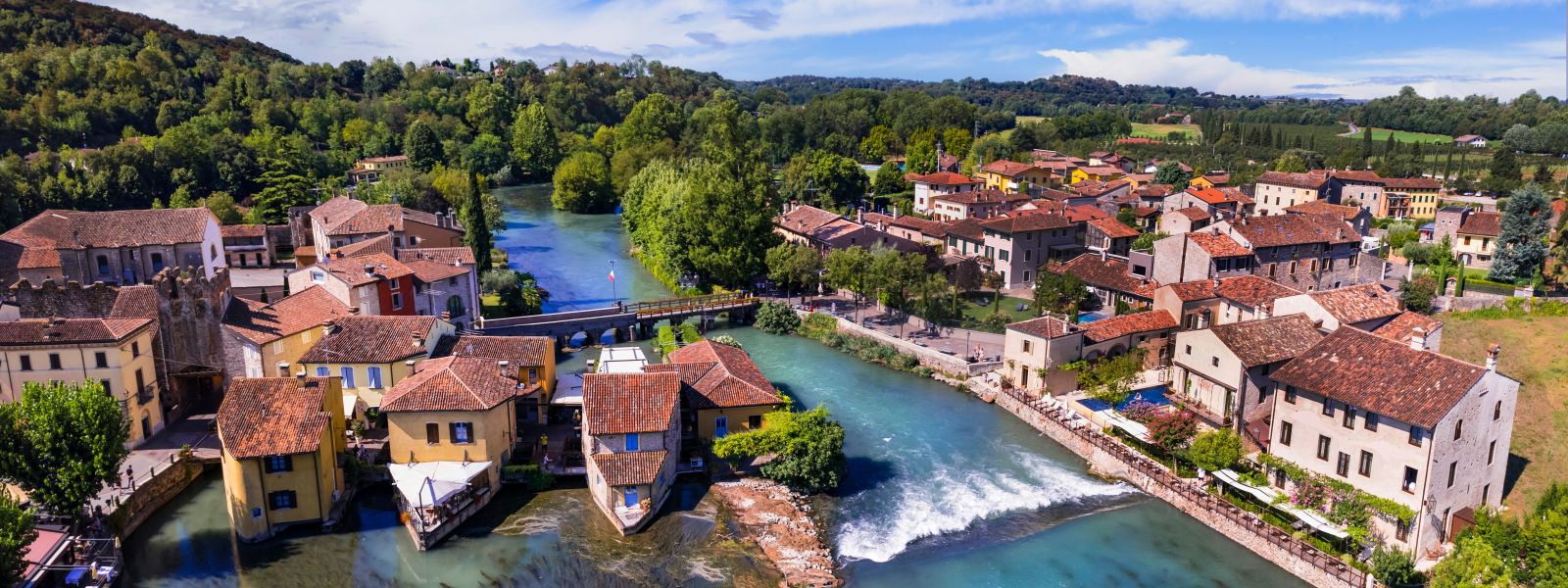 Sanfte Hügel, Weinberge sowie mittelalterliche Dörfer und Gardasee.
