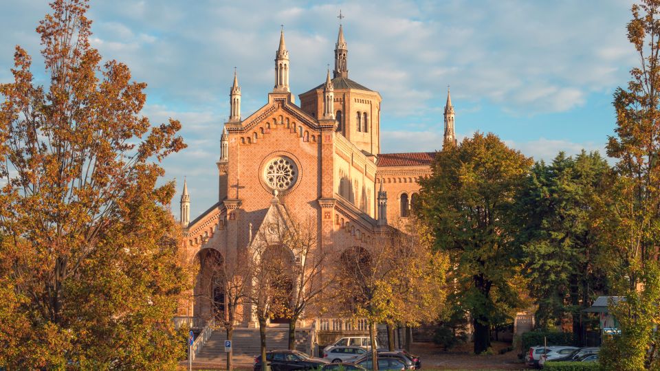 Das Santuario zeigt eine schlichte, harmonische Fassade mit neogotischen Anklängen und wirkt ruhig eingebettet in seine grüne Umgebung.