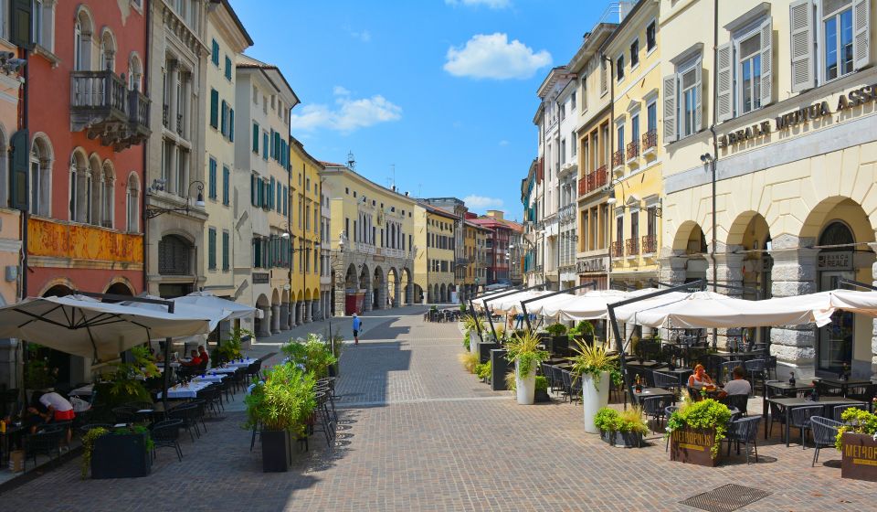 Die Via Mercatovecchio ist eine elegante Einkaufsstraße mit historischen Fassaden, Arkaden und lebendigem städtischem Flair im Herzen Udines.
