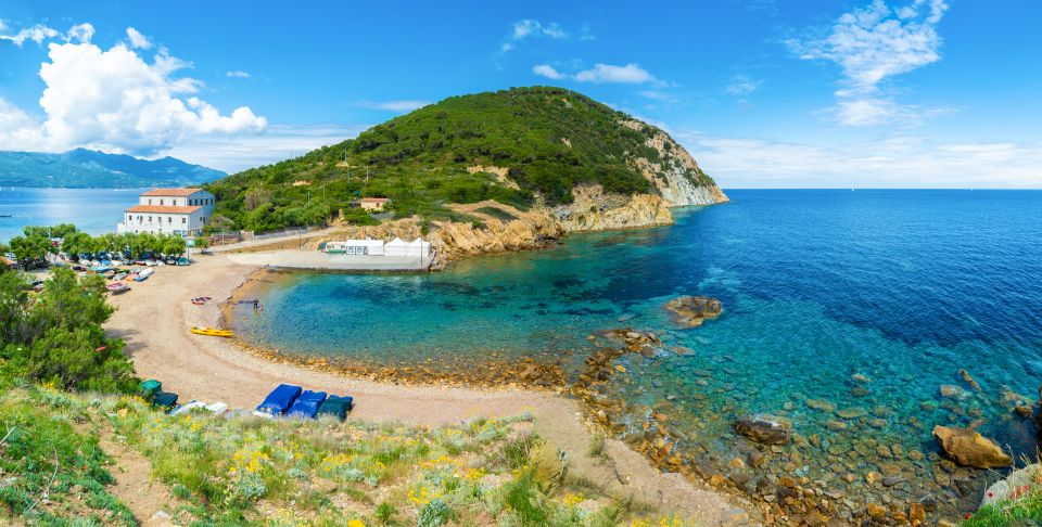 An der Spiaggia dell’Enfola treffen zwei Ufer aufeinander, klares Kieselwasser, Blick zum Monte Enfola und Naturerlebnis.