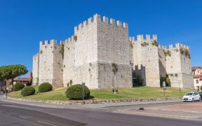 Die Außenansicht zeigt strenge staufische Formen, helle Steinmauern und mächtige Türme als Zeichen kaiserlicher Macht.