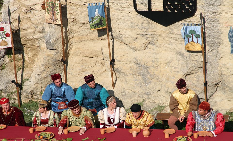 Mittelalterliches Spektakel beim traditionellen Armbrustturnier in San Marino mit Musik, Fahnen und historischen Gewändern.